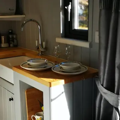 a kitchen counter with two plates and a sink at Pen-Rhos luxury glamping 