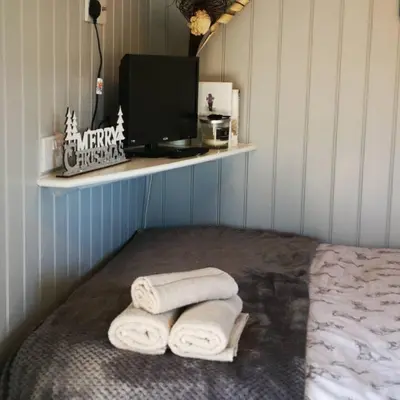 a room with two towels on a bed with a monitor at Pen-Rhos luxury glamping 