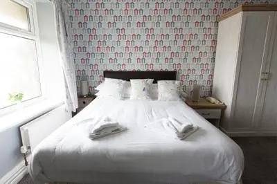 a bedroom with a bed with two towels on it at Min y Mor Hotel in Barmouth