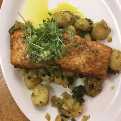a plate of food with fish and potatoes and a salad at Min y Mor Hotel in Barmouth