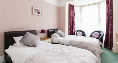 a bedroom with two beds and a window at Rooms by Maes y mor Town Centre in Aberystwyth