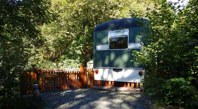 a trailer is parked next to a fence at Showman's Wagon at Coed Cae in Dolgellau