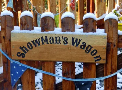 a sign on a wooden fence with snow on it at Showman's Wagon at Coed Cae in Dolgellau