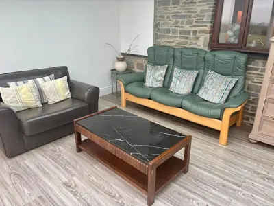 a living room with a green couch and a coffee table at The Milking Parlour in Aberystwyth