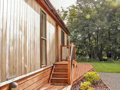 a porch of a house with a wooden stair case at Alder River Lodge Clun Valley Luxury Hot Tub Break in Craven Arms