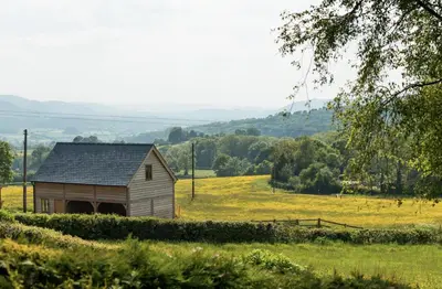 an old barn in a field of grass at Rhiastyn Barn in Hyssington