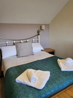 a bedroom with a bed with towels on it at The Stores in Aberystwyth