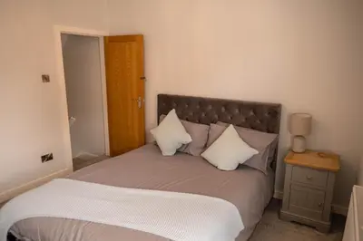 a bedroom with a large bed with white pillows at Rose Cottage in Shrewsbury