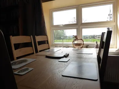 a room with a wooden table with a window and a table sidx sidx at Rhydgaled in Llanon