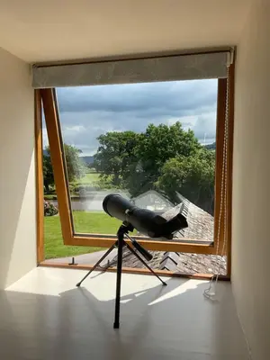 a camera on a tripod in front of a window at Captains Lookout (Studio apartment) in Brecon