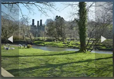 a picture of a park with a river and a tree at The Mews, Talley in Llandeilo