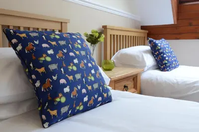 a bed with a blue pillow with animals on it at Neuadd Henllan Lodge in Builth Wells
