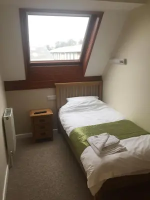 a small bedroom with a bed with a window at Neuadd Henllan Lodge in Builth Wells