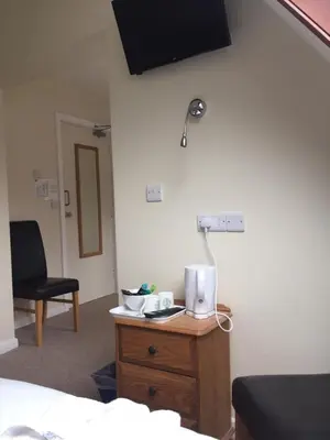 a room with a bed and a desk with a lamp at Neuadd Henllan Lodge in Builth Wells