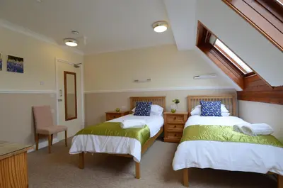 a bedroom with two beds and a staircase at Neuadd Henllan Lodge in Builth Wells