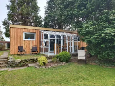a tiny house with a greenhouse in a yard at Indigo Lodge - Aberdovey in Aberdyfi