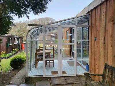 a greenhouse on the side of a house at Indigo Lodge - Aberdovey in Aberdyfi