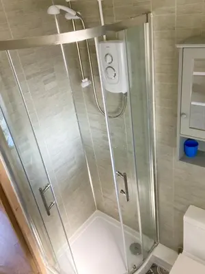 a shower with a glass door in a bathroom at Indigo Lodge - Aberdovey in Aberdyfi