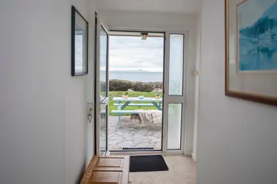 a door leading to a patio with a picnic table at Allt y Mor in Harlech