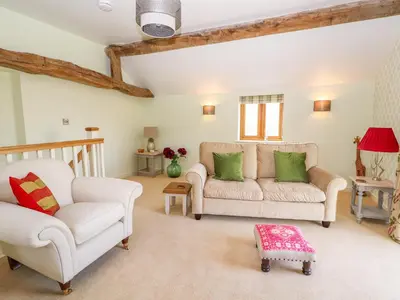 a living room with two chairs and a couch at The Tractor Shed in Oswestry