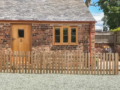 a wooden fence in front of a brick house at The Tractor Shed in Oswestry