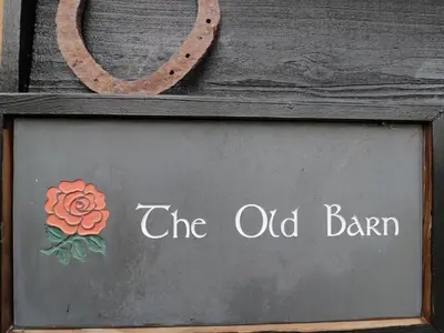 a sign that says the old barn with a flower on it at The Old Barn in Hereford