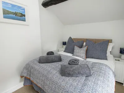 a bedroom with a bed with two towels on it at Rectory Cottage in Oswestry