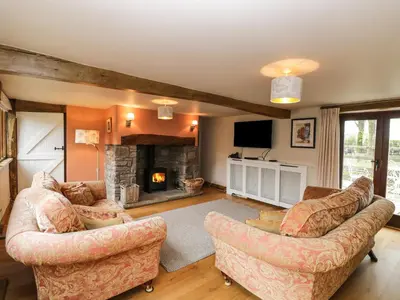a living room with two couches and a fireplace at The Granary in Hereford