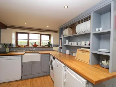 a kitchen with blue cabinets and white appliances at The Granary in Hereford