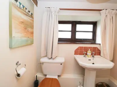 a bathroom with a toilet and a sink and a window at The Granary in Hereford