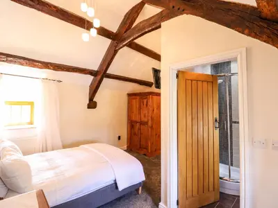 a bedroom with a bed and a wooden ceiling at Cwm Yr Afon Mawr in Llanbedr