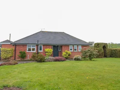 a red brick house with a green yard at Bower View in Hereford
