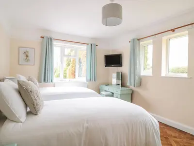 a bedroom with two white beds and two windows at Bower View in Hereford