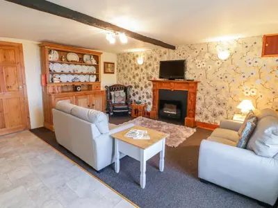 a living room with two couches and a fireplace at The Stable Cottage in Llanbedr