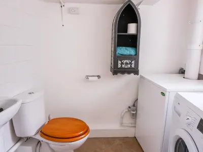 a white bathroom with a toilet and a sink at Bari in Aberaeron