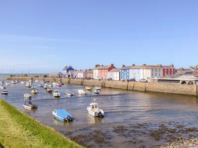 a group of boats in a river with buildings at Bari in Aberaeron