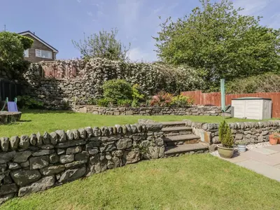 a stone retaining wall in the yard of a house at Clyd Fan in Harlech