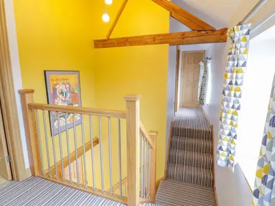 a staircase in a house with yellow walls at 7evern Porth Farm in Caersws