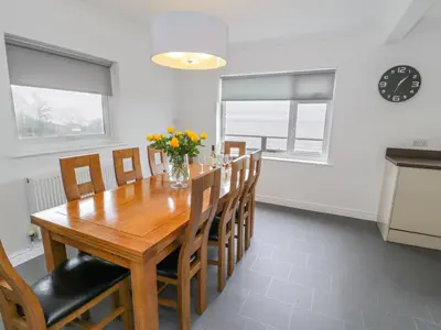 a dining room with a wooden table and chairs at Hendre Wylan in Barmouth