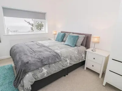 a bedroom with a large bed and a window at Hendre Wylan in Barmouth