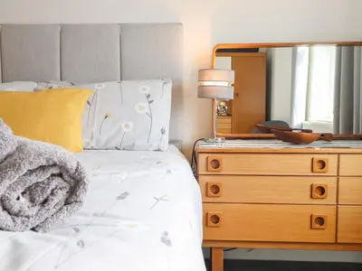 a bedroom with a bed and a dresser with a mirror at Arnant in Dolgellau