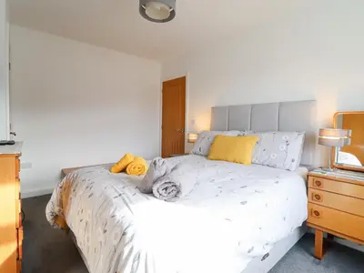a bedroom with a large white bed with yellow pillows at Arnant in Dolgellau