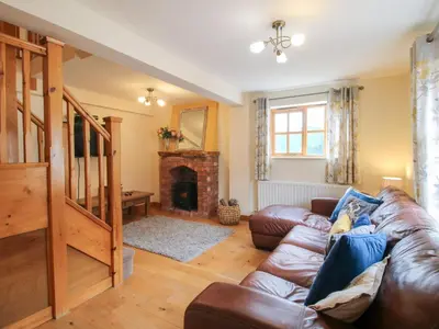 a living room with a couch and a fireplace at Old Hall Barn 2 in Church Stretton