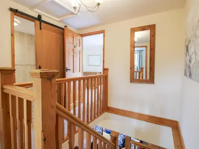 a staircase in a house with a mirror at Old Hall Barn 2 in Church Stretton