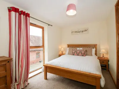 a bedroom with a bed and a window at Old Hall Barn 2 in Church Stretton