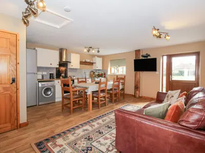 a living room with a couch and a dining room at Old Hall Barn 2 in Church Stretton