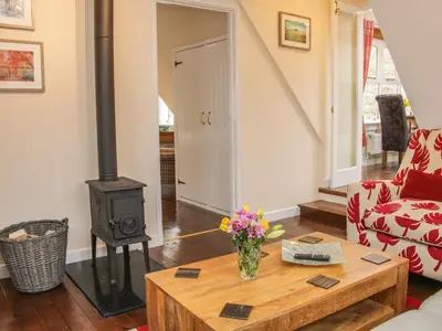 a living room with a wood stove and a table at Ragleth Place Lodge in Church Stretton