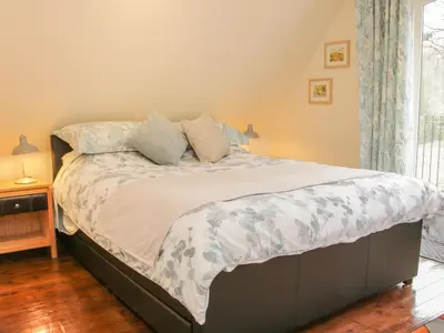 a bedroom with a large bed with a white comforter at Ragleth Place Lodge in Church Stretton