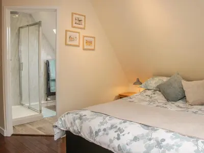 a bedroom with a bed and a glass shower at Ragleth Place Lodge in Church Stretton