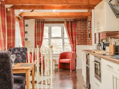 a kitchen with red chairs and a table in a kitchen at Ragleth Place Lodge in Church Stretton
